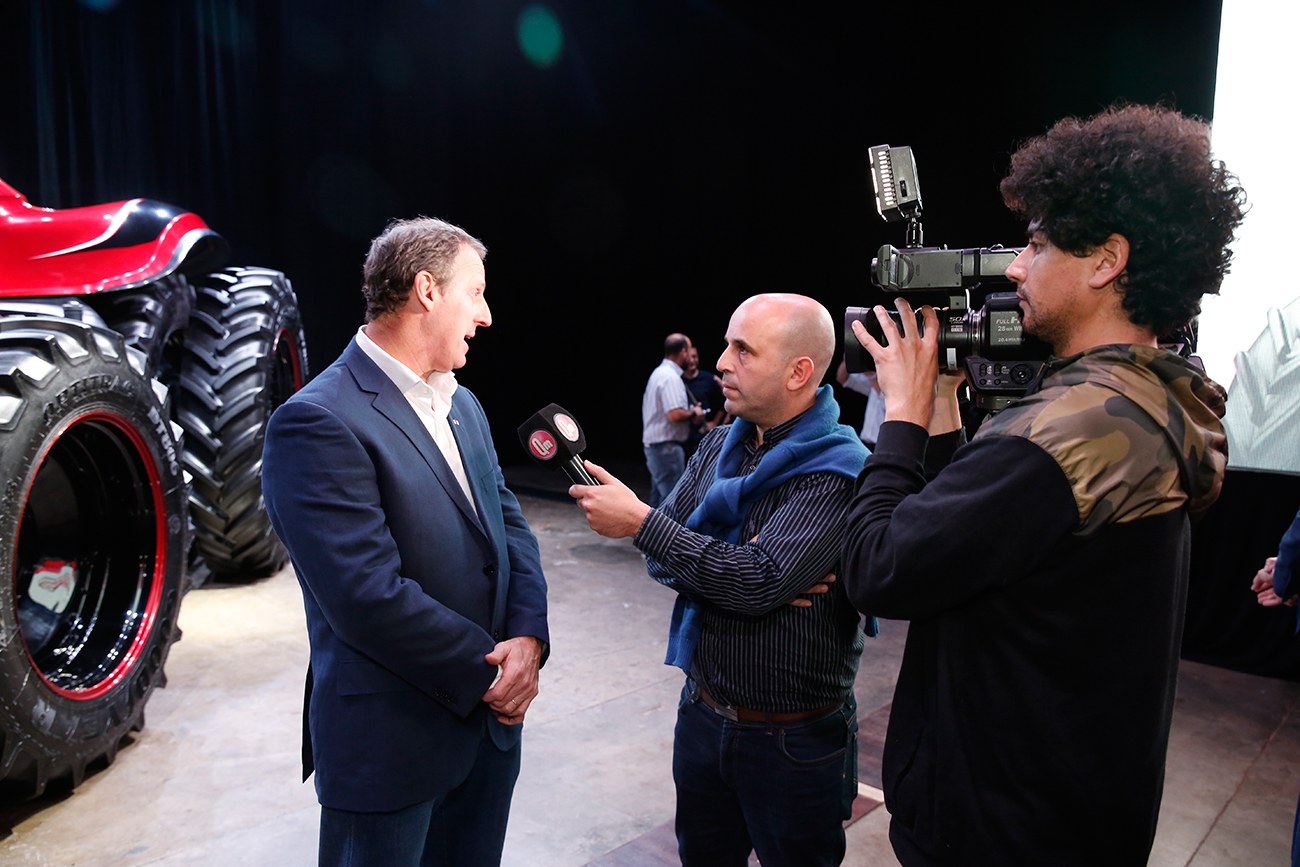Una entrevista audiovisual con el Tractor Autónomo Case IH detrás, durante la presentación.